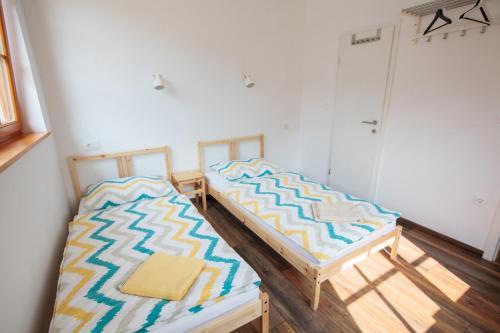 two beds sitting next to each other in a room at BikeSki family hotel, b&b, apartaments, rooms in Mežica