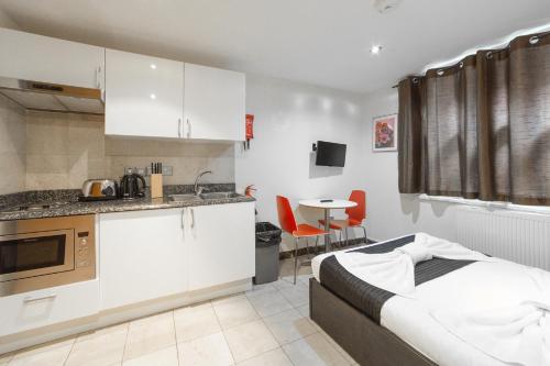 a room with a kitchen and a bed in it at New Kent Apartments in London