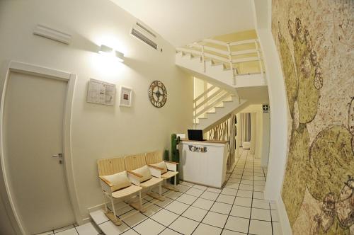 um corredor com cadeiras e uma escada num edifício em Thalìa Guest House Marzamemi em Marzamemi