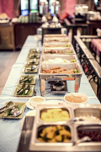 a long table with a row of dishes of food at Buraphat Resort in Chiang Dao