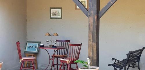 une chambre avec une table, des chaises et une table avec une croix dans l'établissement L' Esterlanges SUITE FAMILLE 2 chambres 4 personnes PROCHE PUYduFOU, à Saint-Vincent-Sterlanges