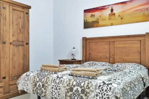 1 dormitorio con 1 cama con cabecero de madera en Ocean sound en Arona