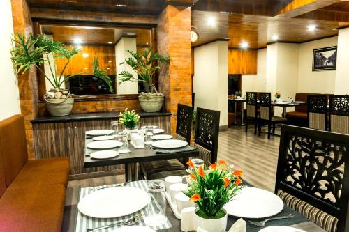 a dining room with tables and chairs and plants at Hotel Tin Tin Boutique Bijanbari in Darjeeling