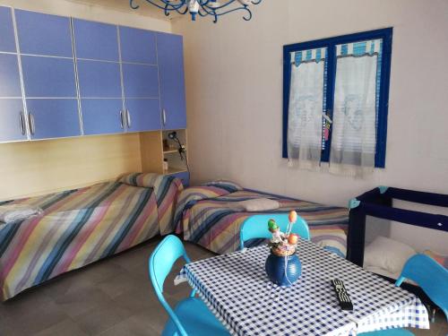 een kamer met 2 aparte bedden en een tafel en stoelen bij Holiday home Riserva Marina Protetta in Siracusa