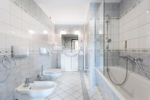 een badkamer met een wastafel, een toilet en een douche bij Qubus Hotel Wrocław in Wrocław