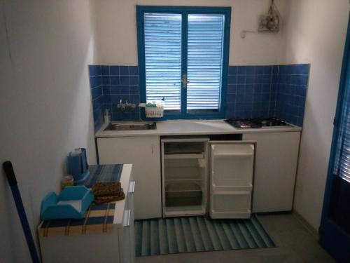 una pequeña cocina con fregadero y ventana en Holiday home Riserva Marina Protetta, en Siracusa