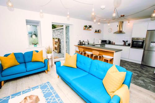 a living room with a blue couch and a kitchen at The Beeches in Killarney