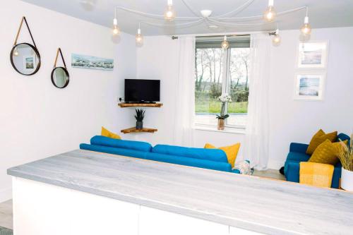 a living room with blue couches and a tv at The Beeches in Killarney