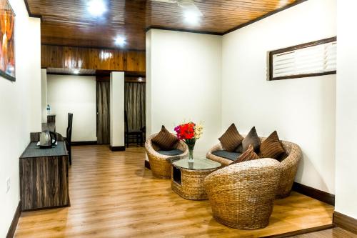 ein Wohnzimmer mit 2 Stühlen und einem Tisch in der Unterkunft Tin Tin Boutique Bijanbari in Darjeeling