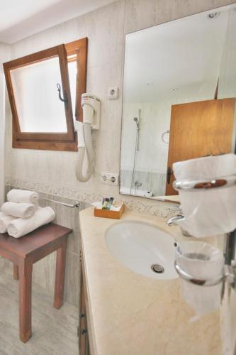 a bathroom with a sink and a mirror at Finca Hotel Rural Predio Son Serra in Can Picafort