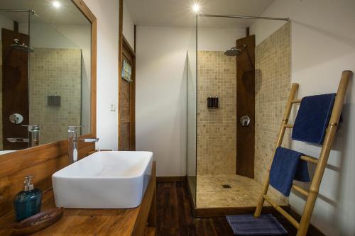 a bathroom with a large white sink and a shower at Orora Bungalows in Canggu