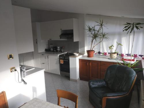 a kitchen with a black leather chair in a room at Apartment Emma in Mali Lošinj