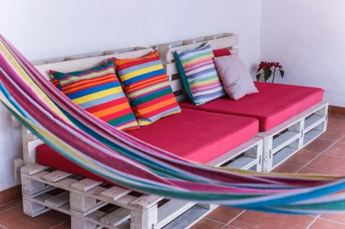 a hammock bed with colorful pillows on it at Casas do Bárrio in Alcobaça