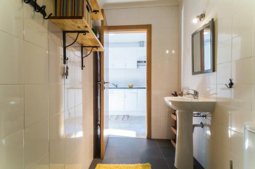 a bathroom with a sink and a shower and a mirror at Casas do Bárrio in Alcobaça