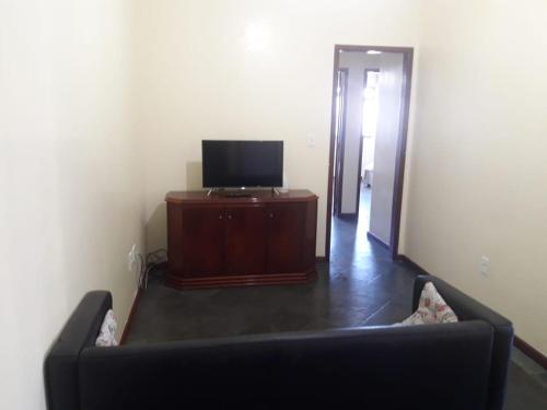 a living room with a couch and a flat screen tv at Dom Yargo II in Arraial do Cabo