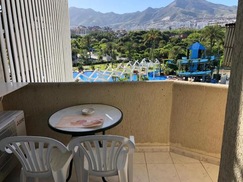 a table and chairs on a balcony with a view of a pool at Benal Beach Paradise in Benalmádena