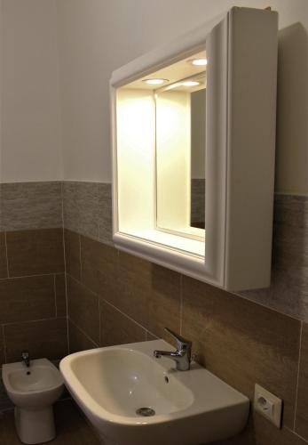 a bathroom with a sink and a mirror and a toilet at Il Viterbino Struttura convenzionata con impianti termali in Viterbo