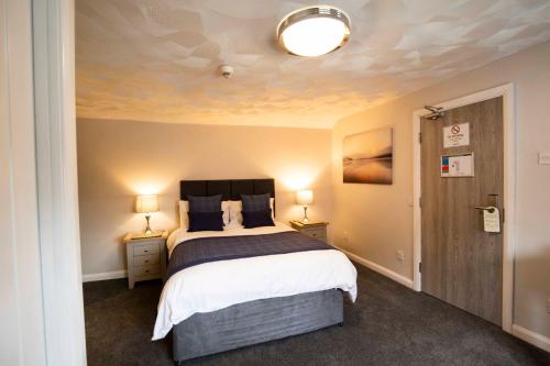a bedroom with a large bed and two lamps at The Kinderton in Middlewich