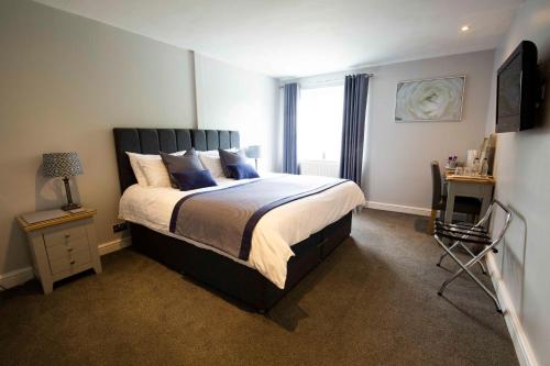 a bedroom with a large bed and a window at The Kinderton in Middlewich