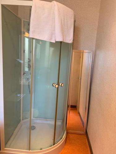 une cabine de douche avec une serviette. dans l'établissement Hotel des voyageurs Chez Betty, à Neussargues-Moissac