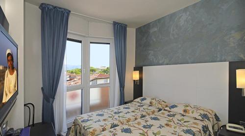 a bedroom with a bed and a large window at Hotel Eur in Lido di Camaiore