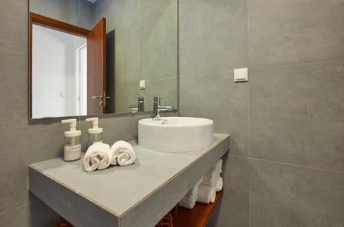 a bathroom with a sink and a mirror at Pedra Branca Apartments in Ericeira