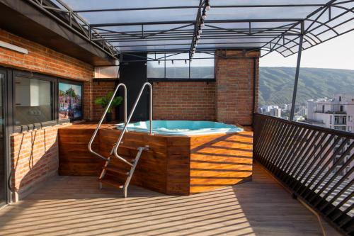 a hot tub on a balcony with a chair at Boutique Hotel in Tbilisi City