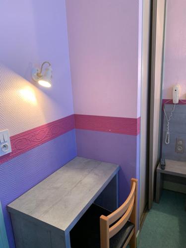 a small room with a table and a chair at Hotel des voyageurs Chez Betty in Neussargues-Moissac