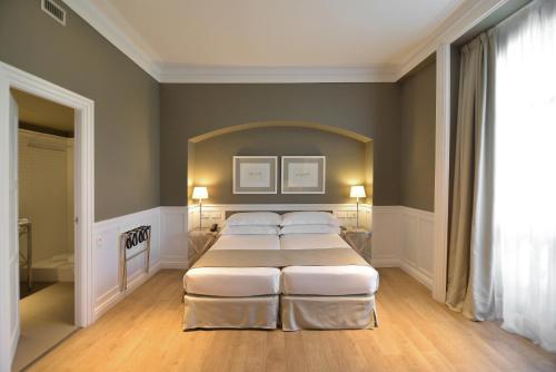 a bedroom with two beds and a large window at Hotel Granvia in Barcelona