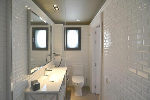 a white bathroom with a sink and a toilet at Hotel Granvia in Barcelona