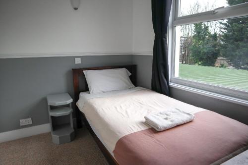 a small bedroom with a bed and a window at Hotel 261 in London