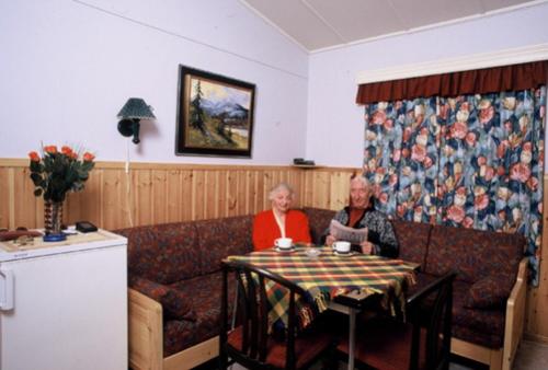 a person sitting at a table in a restaurant at Fauske Camping & Motel in Fauske