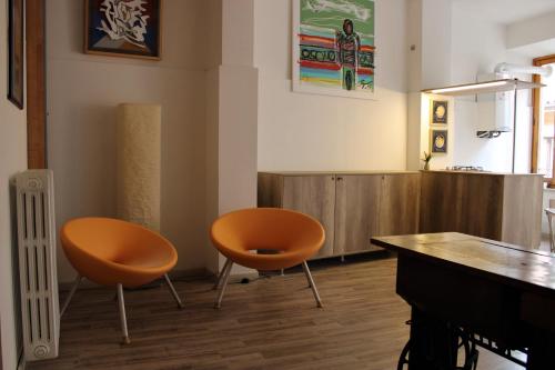 a room with two orange chairs and a table at Il Viterbino Struttura convenzionata con impianti termali in Viterbo
