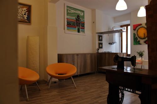 a living room with two orange chairs and a table at Il Viterbino Struttura convenzionata con impianti termali in Viterbo