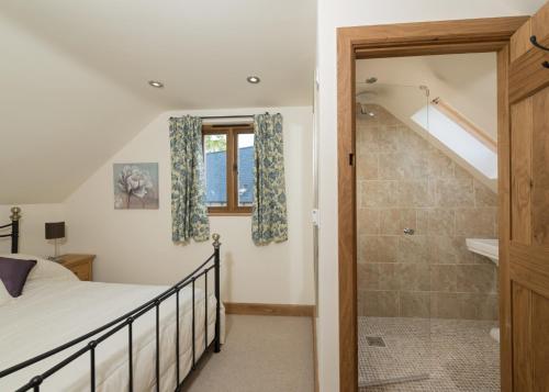 a bedroom with a bed and a shower and a staircase at Rhiastyn Barn in Hyssington