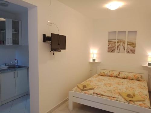 a bedroom with a bed and a tv on the wall at Apartments Stefan in Sveti Stefan