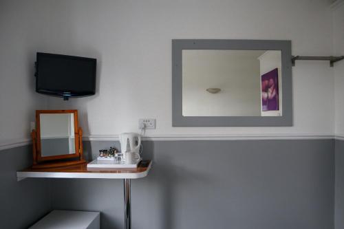 a bathroom with a mirror and a shelf with a sink at Hotel 261 in London