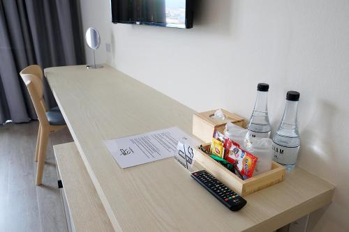 a table with two bottles and a remote control at Siam Mansion - SHA in Hat Yai