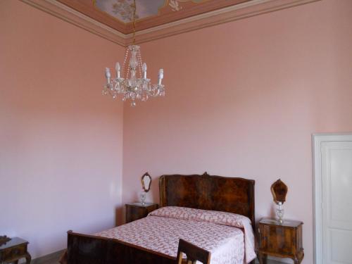 una camera da letto con un letto e un lampadario di Borgo Due Mari a Taranto