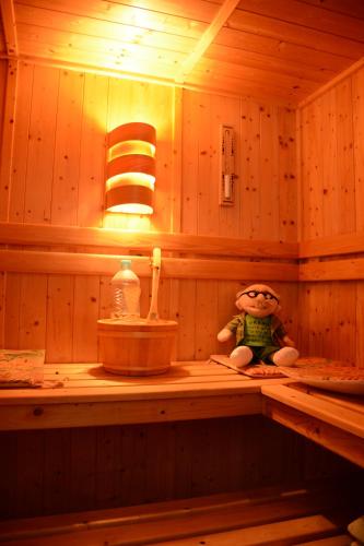 a teddy bear sitting on a shelf in a sauna at Les noyers aulnay in Aulnay