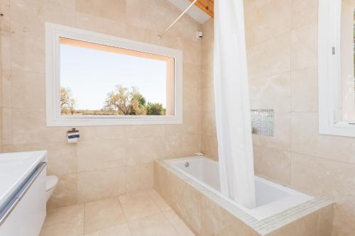 baño con bañera y ventana en Casa Calma, en Llucmajor