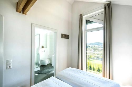 a bedroom with a bed and a large window at Panoramahaus _100_ im Feriendorf a in Truppach
