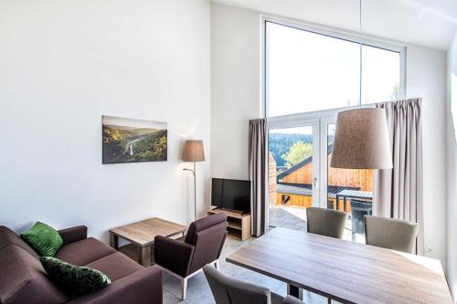 Truppach的住宿－Panoramabungalow _Gal_ im Feriendo，客厅设有桌子和大窗户