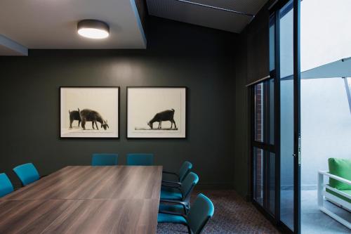 a conference room with a wooden table and blue chairs at Home Suite Hotels Rosebank in Johannesburg