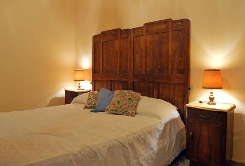 a bedroom with a bed with a large wooden headboard at B&B Lady Cocca in Savio di Ravenna
