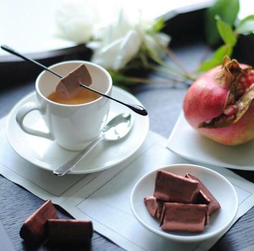 a table with a cup of coffee and a plate of chocolate at Villa La Maggiorana in Rivoli