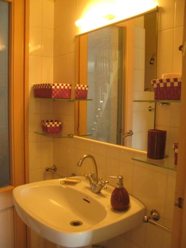a bathroom with a white sink and a mirror at Casa Le Bouganville in Sant Vicenç de Montalt