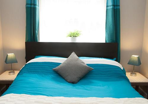 a bedroom with a blue bed with a large window at Hotel 261 in London