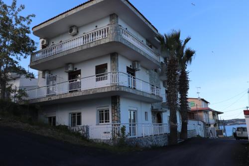 a white building with a balcony and a palm tree at Kalntera in Ammouliani
