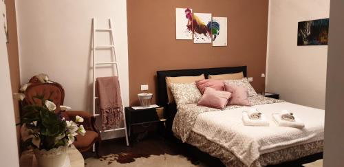 a bedroom with a bed with pink pillows and a ladder at La petite maison in Treviso